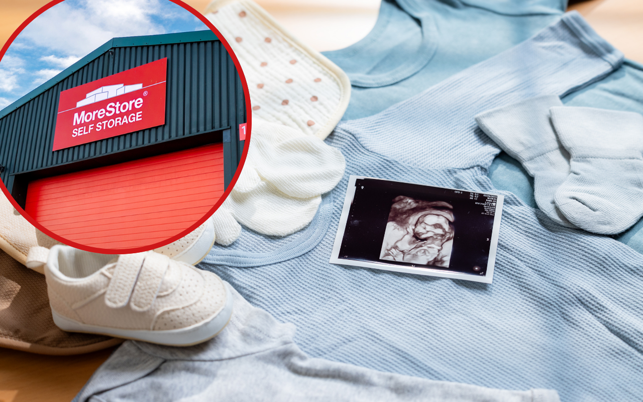 Baby clothes, shoes, mittens and an ultrasound scan arranged on a blue outfit, alongside a MoreStore Self Storage facility sign, representing preparing your home for a new baby with self storage.
