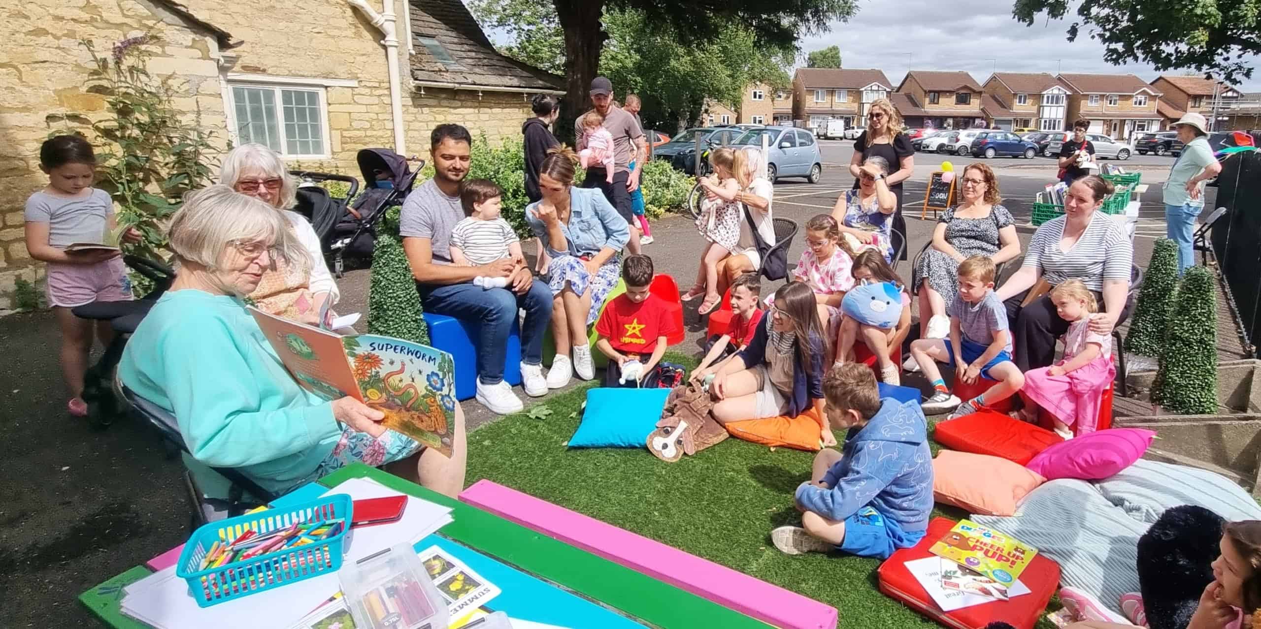Families with young children sat on the floor listening to someone read a book